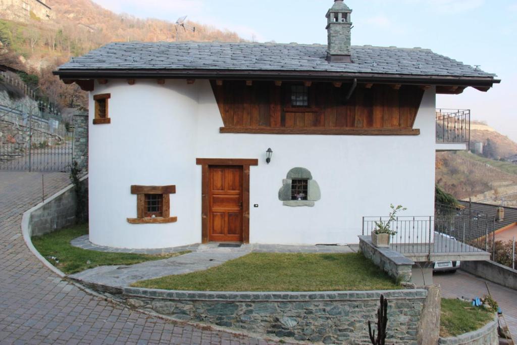 努斯Villa La Tour的一间白色的小房子,设有木门