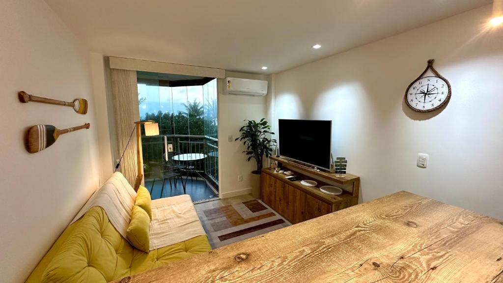 尼泰罗伊Camboinhas Loft Vista Mar, Pé na Areia, com Piscina e Churrasqueira的一间卧室配有一张大床,墙上挂着一个时钟