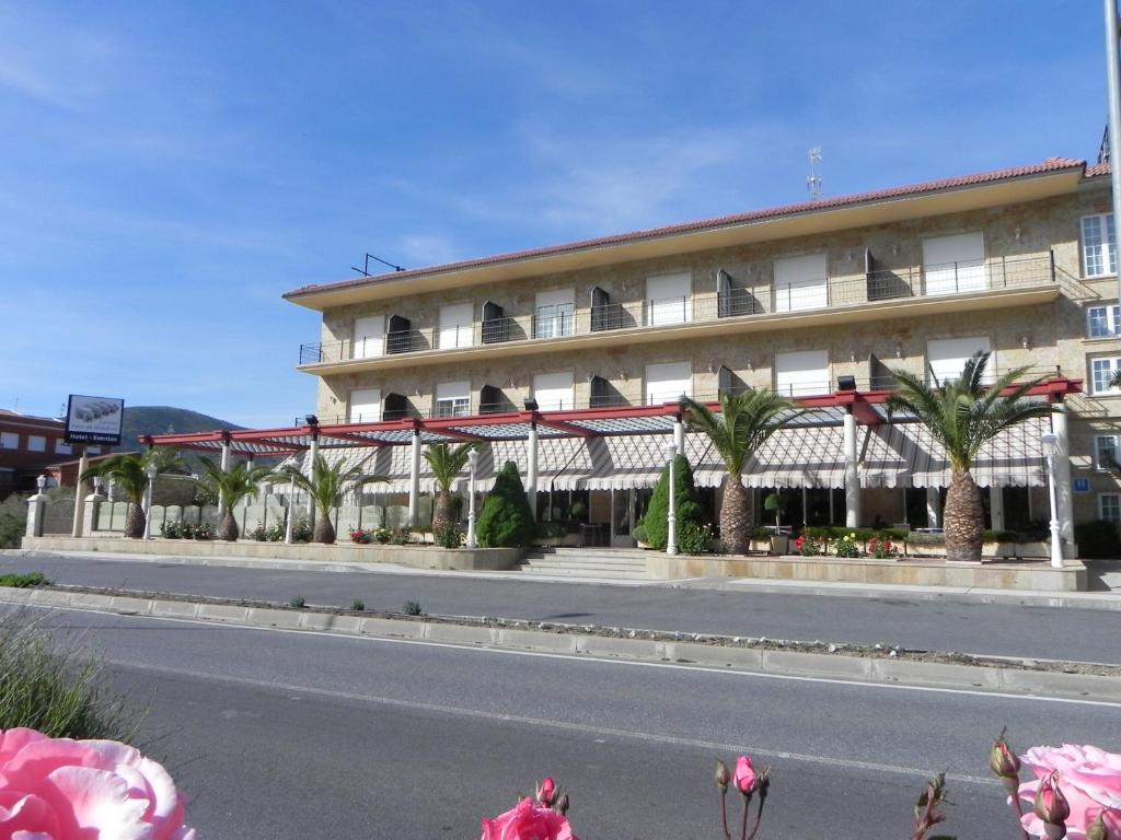 埃尔蒂恩夫洛托洛斯迪谷逸三都酒店的街道前方有棕榈树的建筑