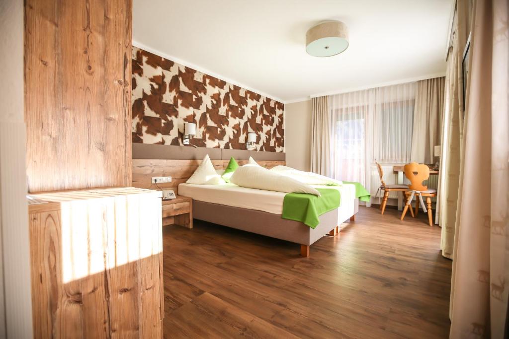 迈尔霍芬卡拉兰德豪斯酒店的卧室配有1张床、1张桌子和1把椅子
