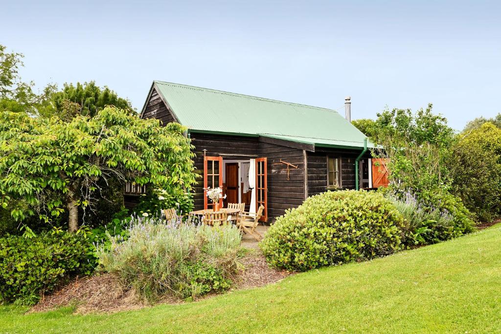 Waimauku库姆葡萄园酒店的一座带绿色屋顶的小木房子