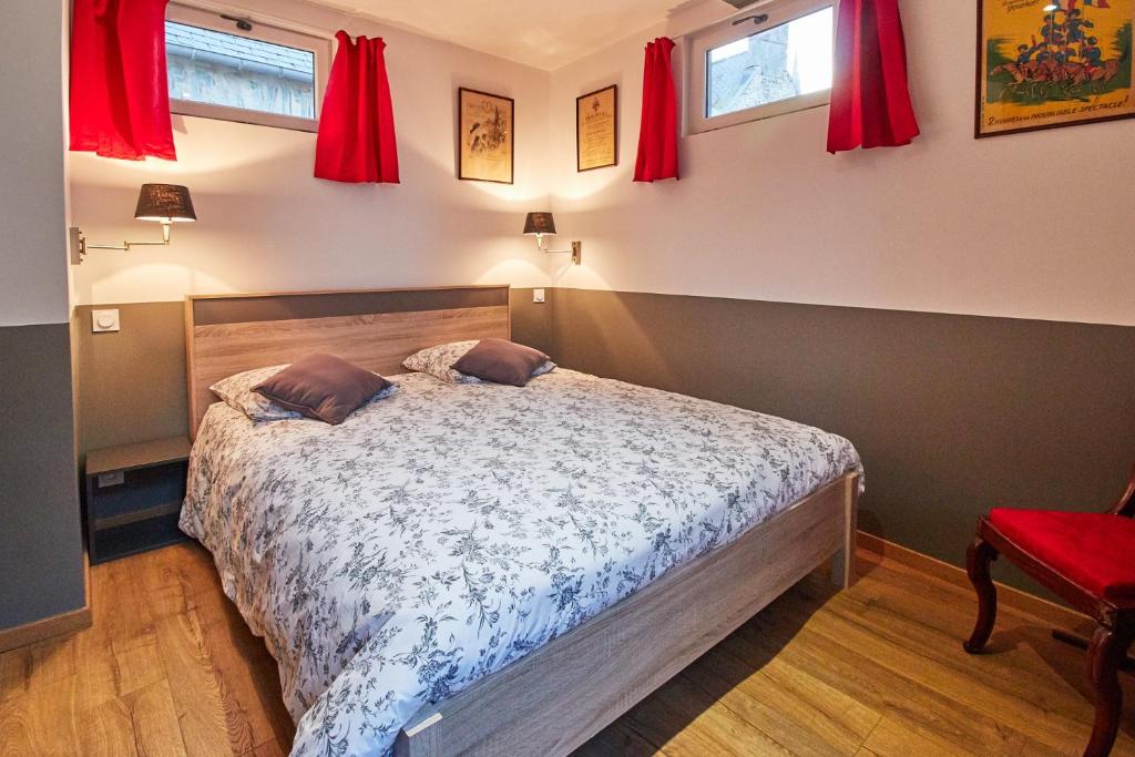 贝叶法国最小的房子度假屋的一间卧室配有红色窗帘的床