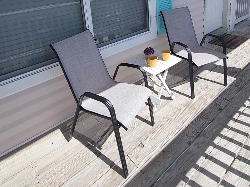 格尔夫海岸Condo in Gulf Shores King Suite的门廊上的两把椅子和一张桌子