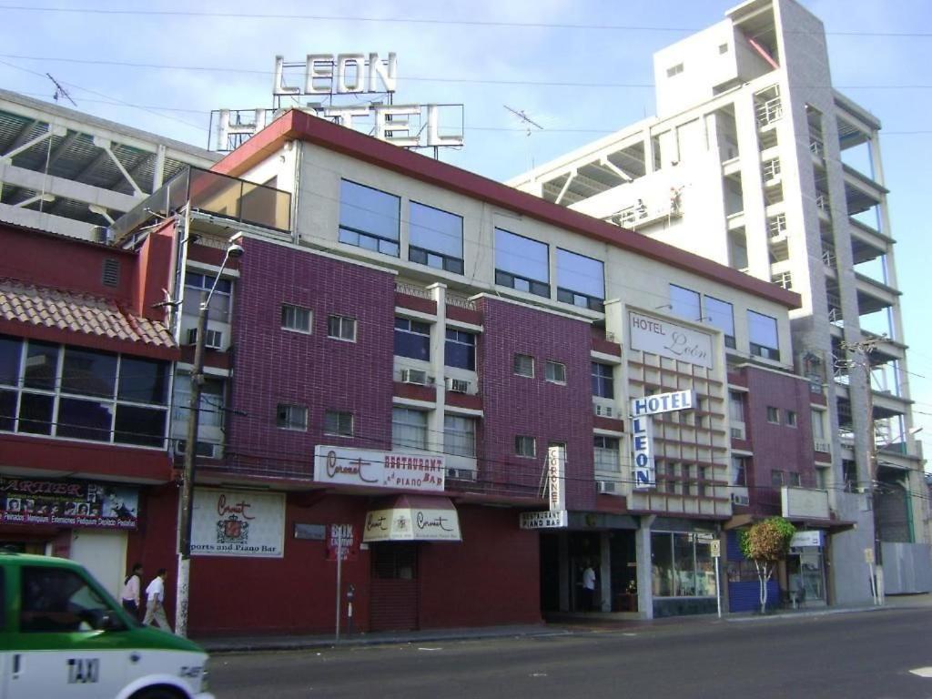 提华纳Hotel León的一座红色的建筑,上面有标志