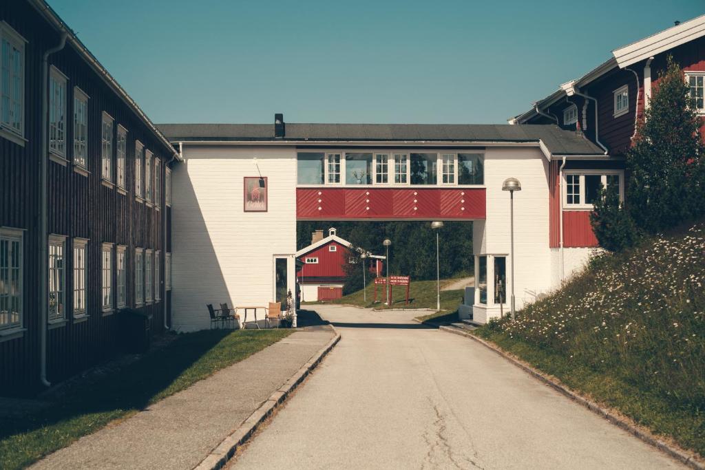 Gålå Høgfjellshotell的通往一座红色车库的建筑的道路