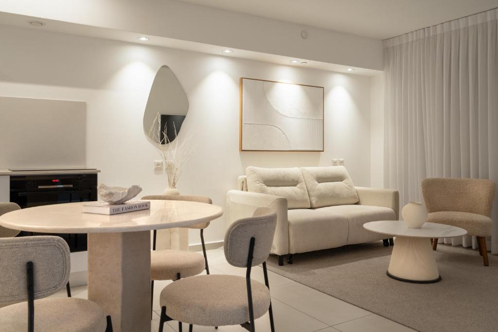 埃拉特Nathan&#39;s Suites On The Beach的带沙发、桌子和椅子的客厅