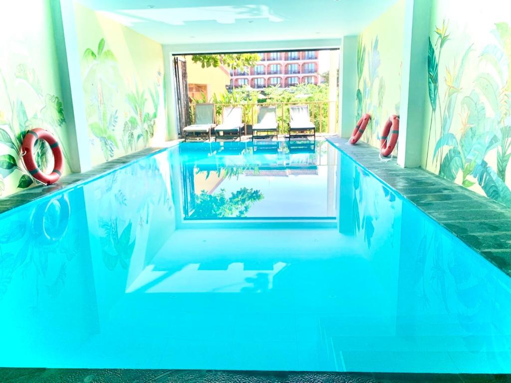 会安De Vivre Hoi An Hotel的酒店内有一个蓝色的游泳池