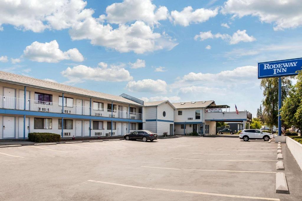 科达伦Rodeway Inn Coeur d'Alene的停车场内有车辆的旅馆