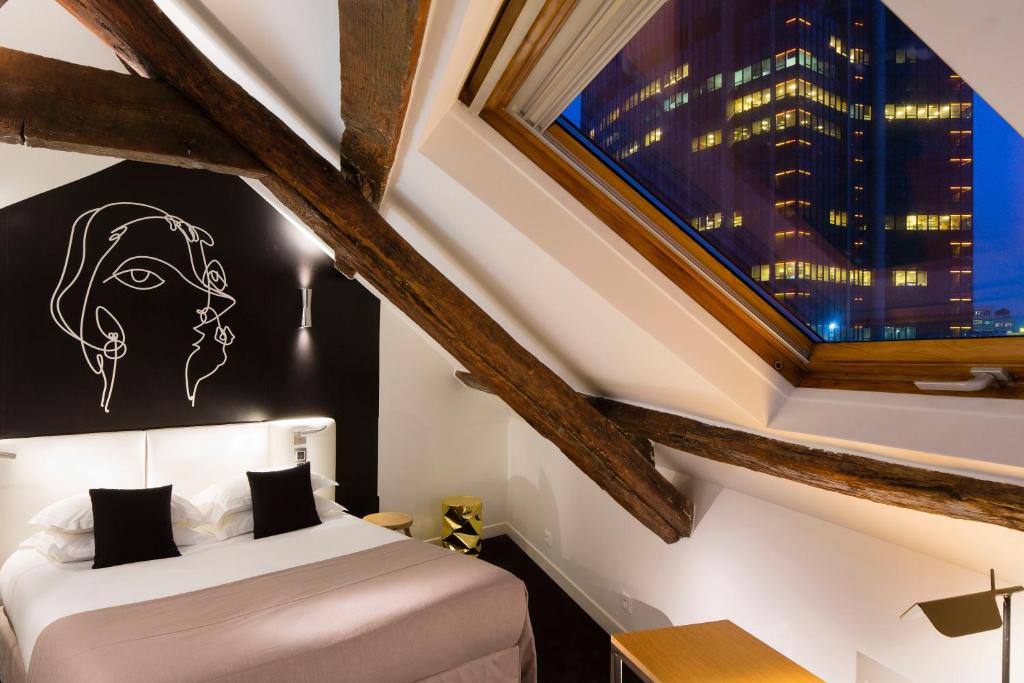 巴黎蒙帕纳斯圣日耳曼酒店的一间卧室设有一张床和一个大窗户