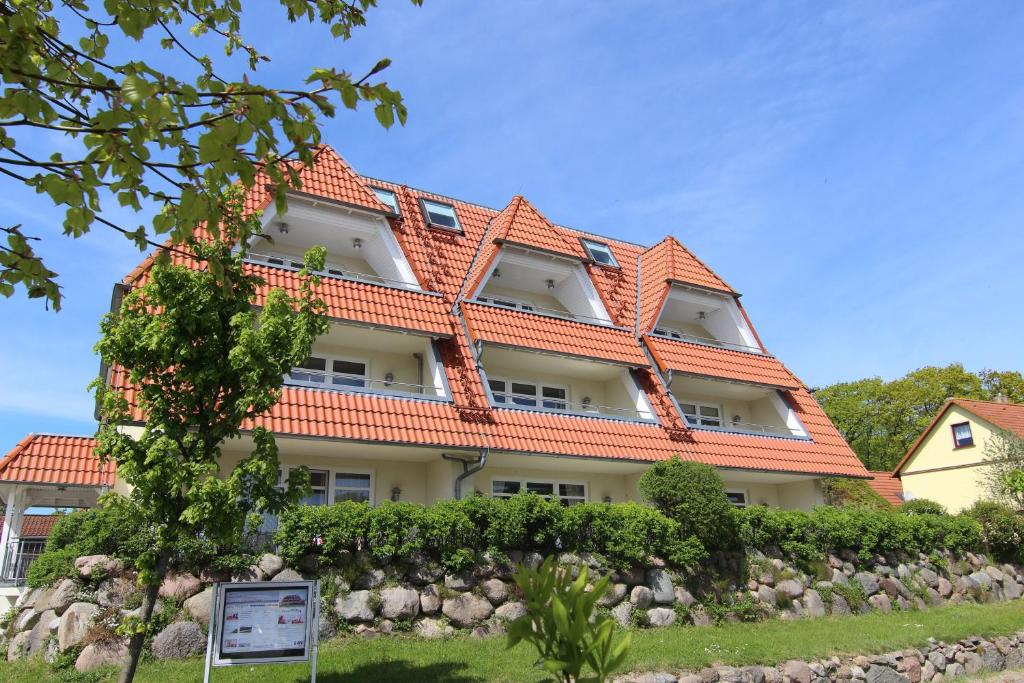 布雷格Hafenhäuser Breege - Ferienwohnung 9 Strandläufer的一座带橙色屋顶的大型建筑
