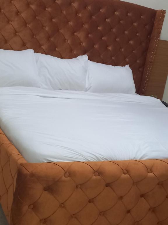 贝宁城Tovia Hotel and Suite Limited的一张铺着白色床单和枕头的大床