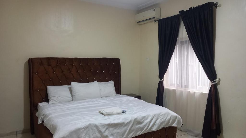 贝宁城Tovia Hotel and Suite Limited的一间卧室配有一张床,上面有电话