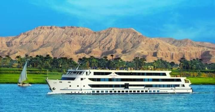 阿斯旺Royal Nile Cruise Aswan to Luxor 3 Night的一艘大白船在水面上,有帆船