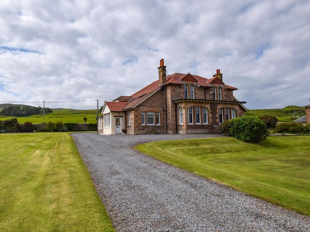 Machrihanish5 bed property in Machrihanish CA291的一座带碎石车道的大型砖屋