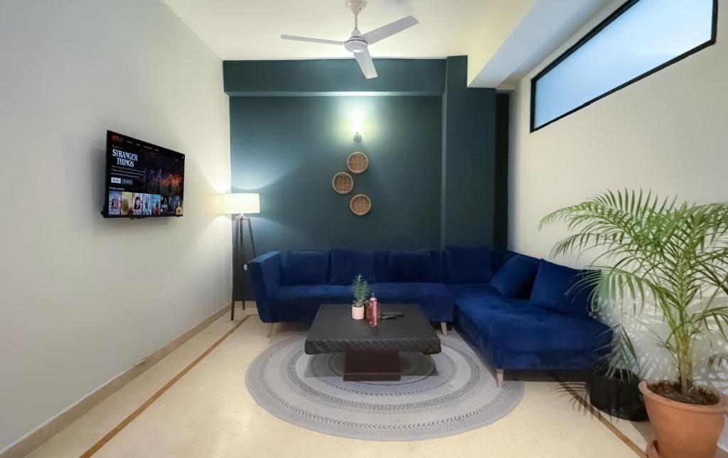 伊斯兰堡The Comfort Hub, 2 Bedroom apartment, Islamabad的客厅配有蓝色的沙发和桌子