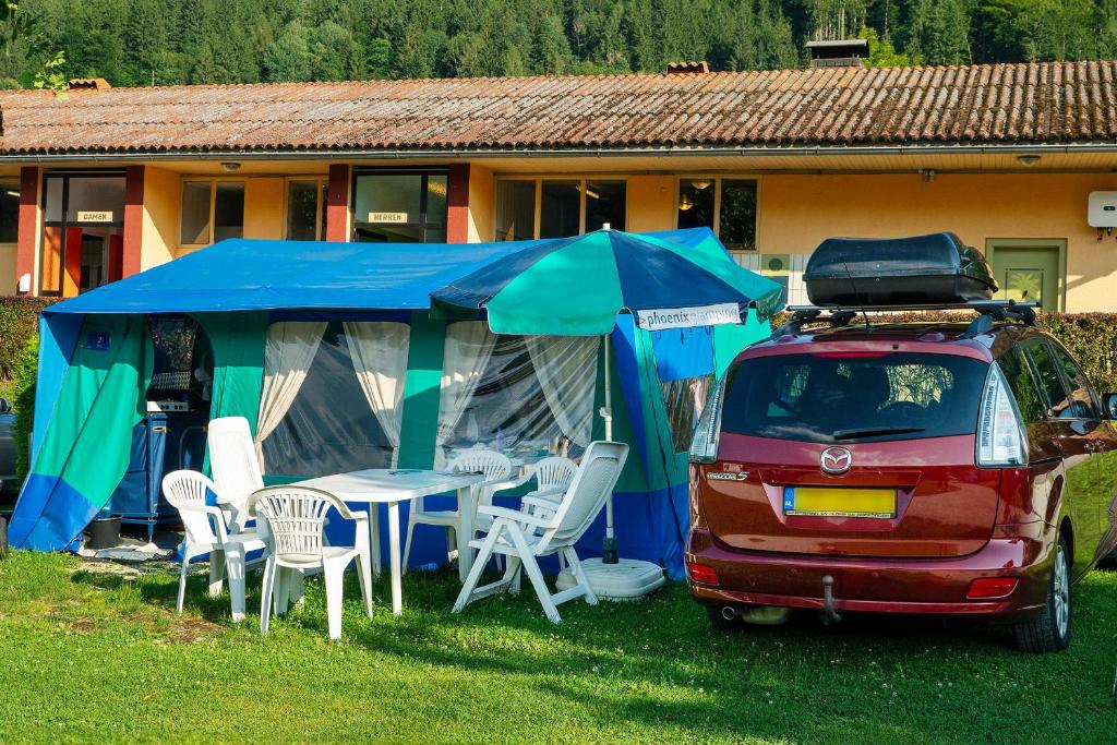 Altossiachphoenix glamping at camping Lampele的一辆带帐篷和桌椅的面包车