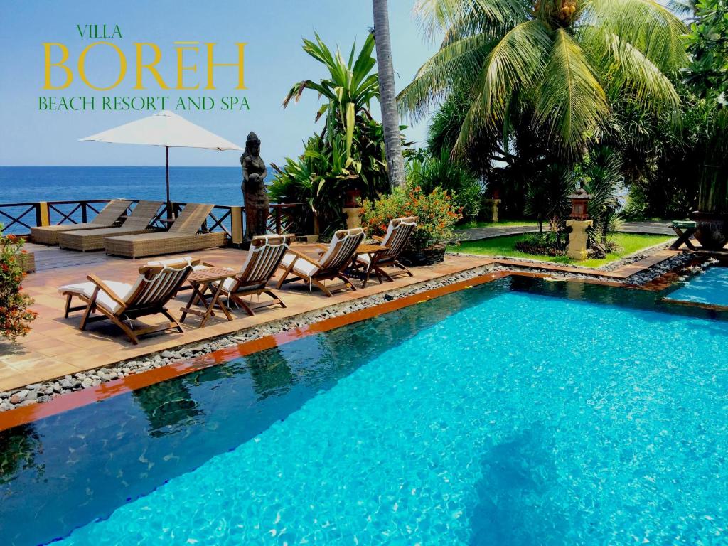 特贾库拉博勒海滩别墅Spa度假酒店的毗邻大海的带躺椅和椅子的游泳池
