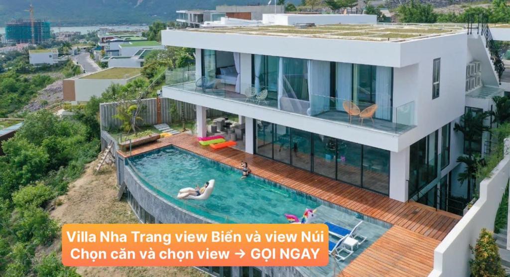 芽庄Villa Nha Trang Gần Biển - Biệt Thự Nha Trang Gần Biển的一座带游泳池的房子,里面的人