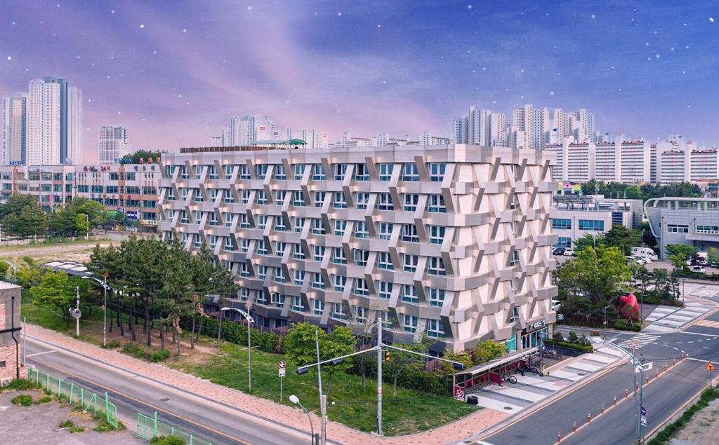 束草市Chungchoho Best Hotel的城市街道上的公寓楼,有建筑