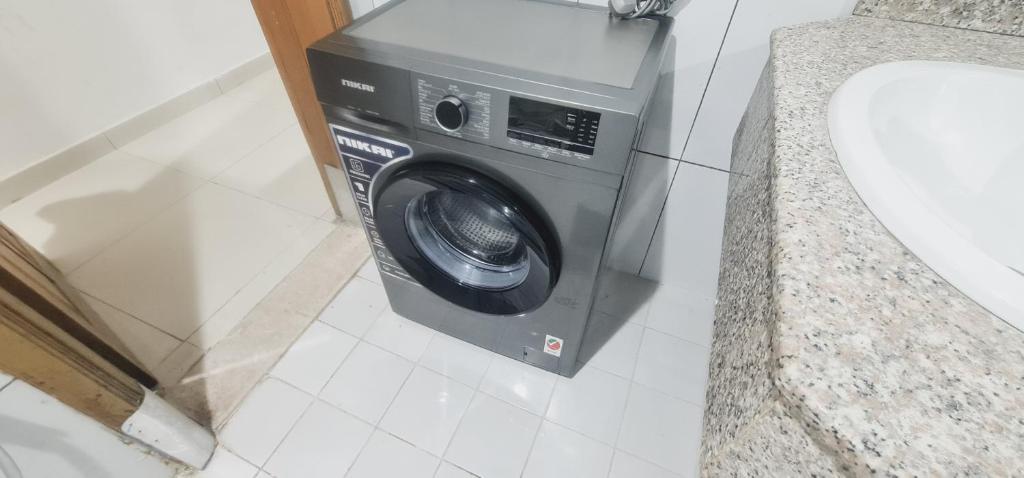 迪拜LA Gold hostel capsule的盥洗盆旁浴室内的洗衣机