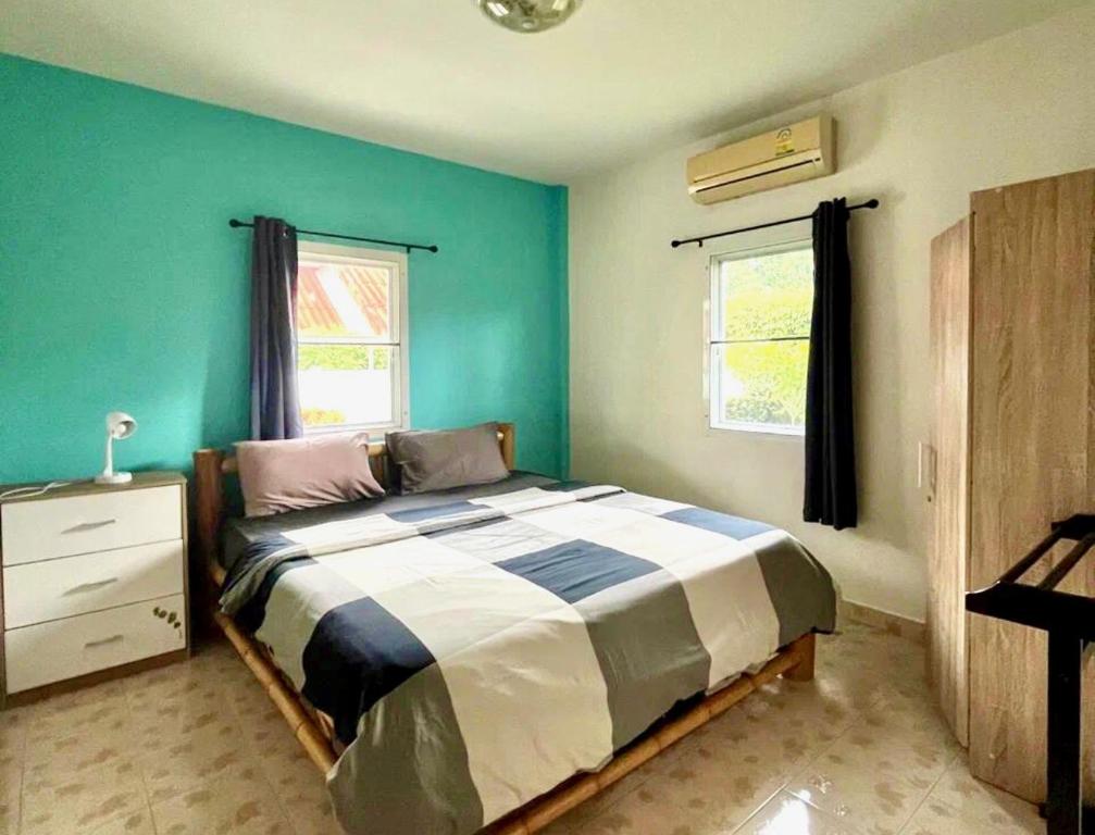 Ban Suan2 bedroom bungalow Nai Harn 4 Resort的一间卧室设有一张床和绿色的墙壁