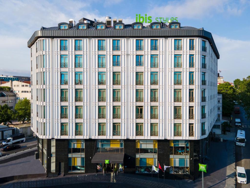 伊斯坦布尔ibis Styles Istanbul Merter的白色的建筑,上面有标志