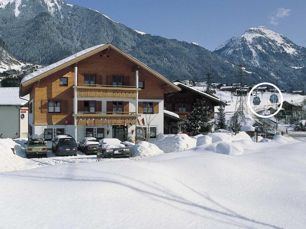 圣加伦基希Aparthotel Spitzer的雪地里停有车辆的滑雪小屋