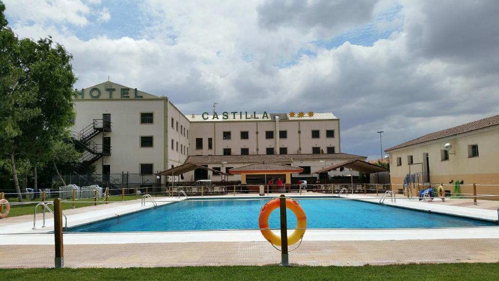 托里霍斯Hospedium Hotel Castilla的大楼前的大型游泳池