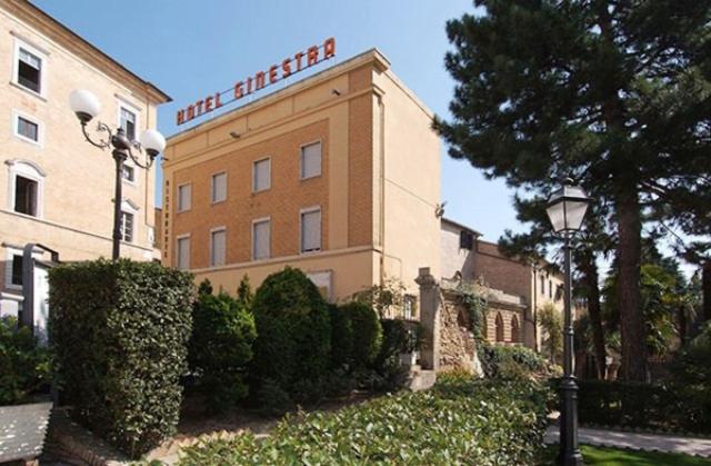 雷卡纳蒂Hotel Ristorante La Ginestra的建筑一侧有标志的酒店