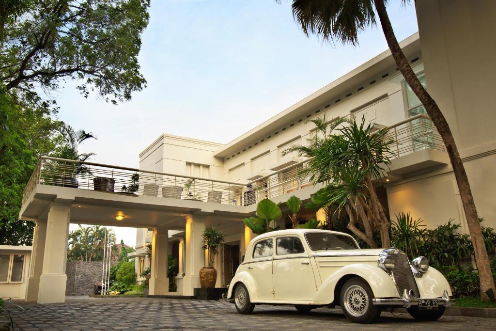 玛琅萨里玛尔精品酒店的停在大楼前的旧白车