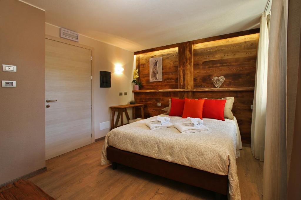 萨奥兹-杜尔克斯情缘酒店的一间卧室配有红色枕头的床