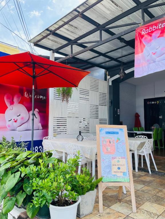 普吉镇Rabbitel Phuket的一张桌子,上面有红伞和标志