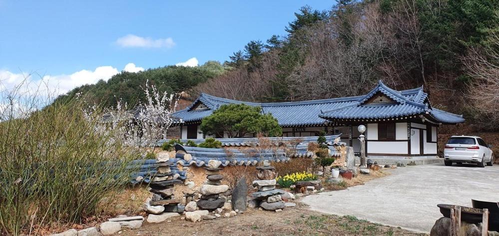 江陵市Gangneung Wangsangoal Hanok Pension的一栋建筑前停着一辆车