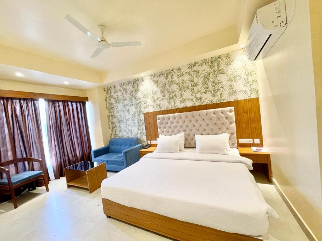 普里HOTEL PETAL ! PURI होटल पेटल হোটেল পাপড়ি హోటల్ పెటల్ fully-air-conditioned-hotel with-lift-and-parking-Card Payment Accepted-facility breakfast-included Best Hotel in Puri 2的一间卧室配有一张床和一张蓝色椅子