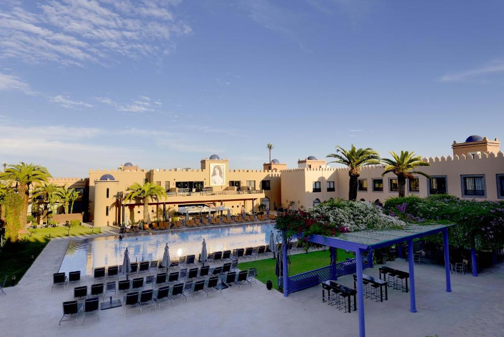 马拉喀什马拉喀什亚当公园酒店及水疗中心的一座带桌椅的度假村和一座建筑