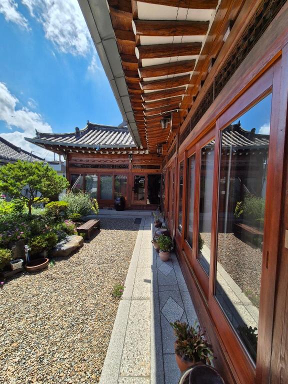庆州Yeonyijae hanok stay的一座有门廊的建筑,上面有盆栽植物