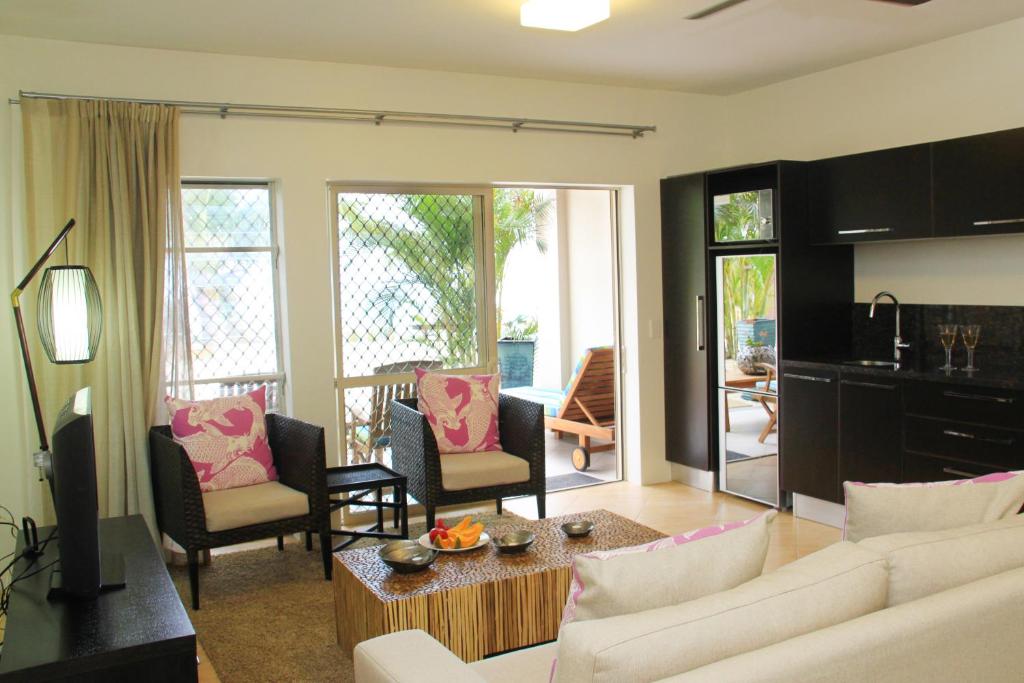 拉罗汤加莫阿纳沙滩别墅公寓的客厅配有白色的沙发和椅子