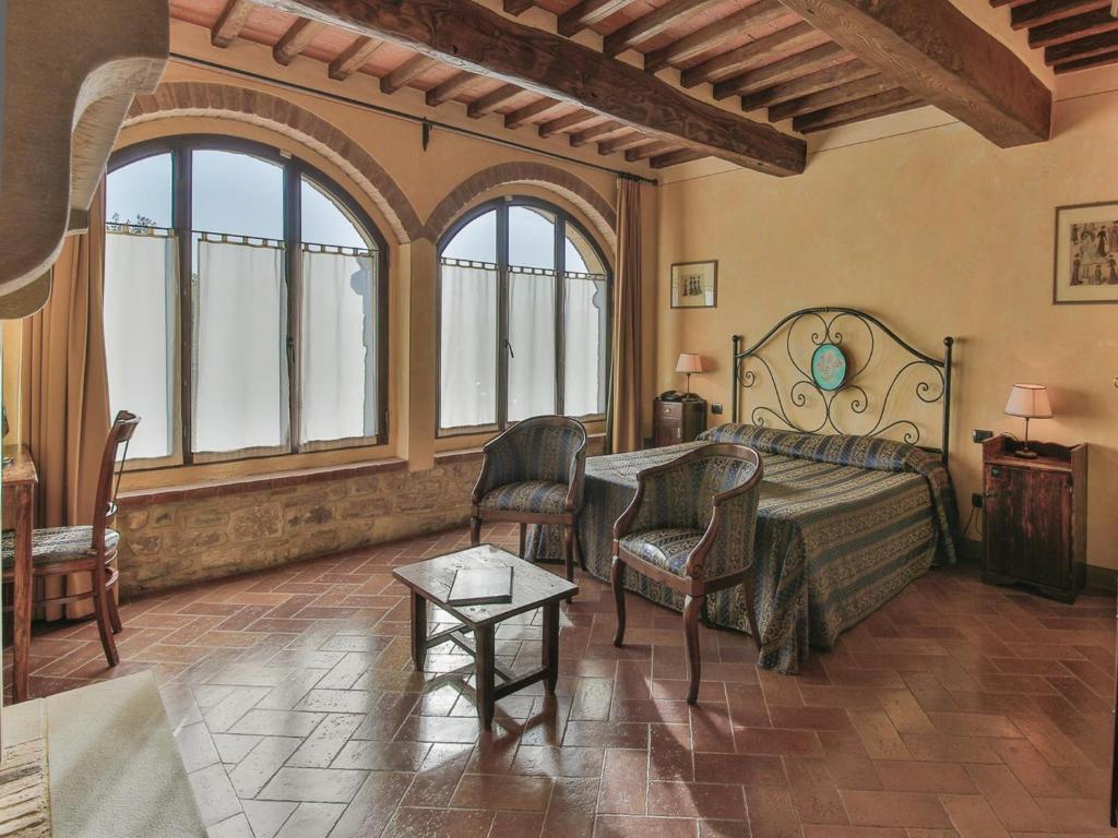 基安蒂盖奥勒勒波泽迪利奇酒店的一间卧室配有一张床、椅子和窗户。