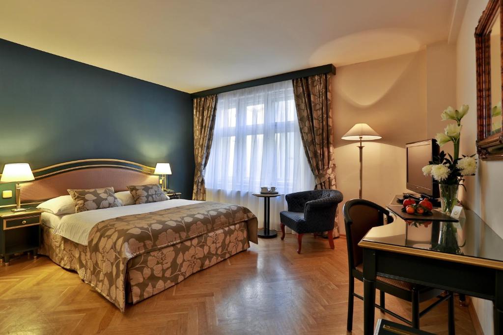布拉格爱丽舍酒店的配有一张床和一张书桌的酒店客房