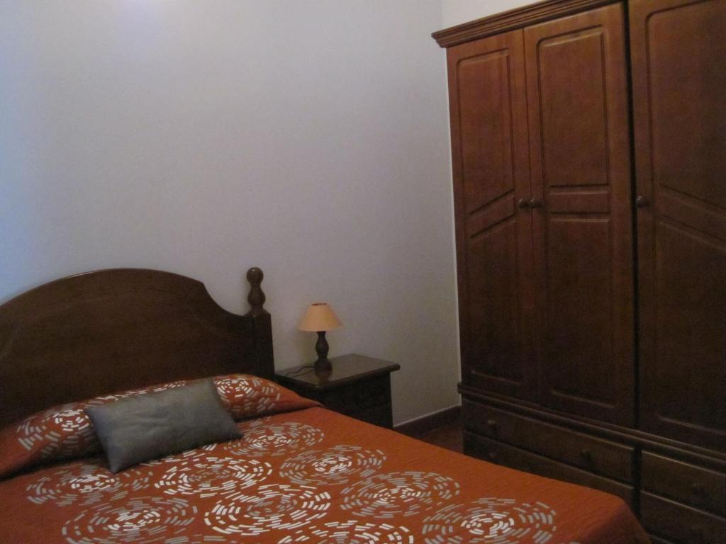 SabinosaApartamentos Viviendas Vacacionales Pozo de La Salud的一间卧室配有一张床和一个大型木制橱柜