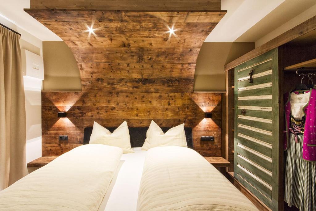 塞尔瓦迪加尔代纳山谷Chalet Da Mont的一间卧室设有两张床和砖墙