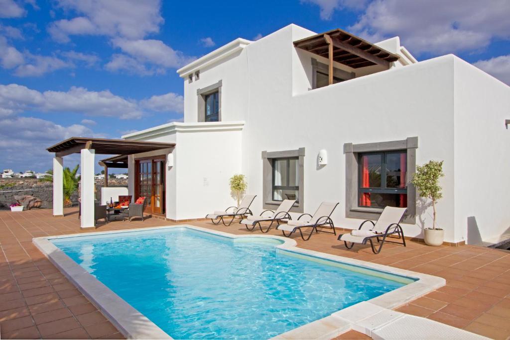 普拉亚布兰卡Villas Coral Deluxe的别墅前设有游泳池