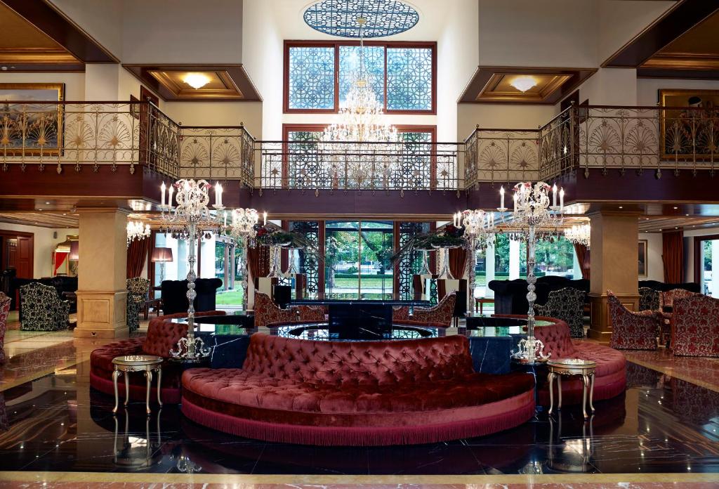 约阿尼纳豪华土耳其宫殿会议酒店及Spa的大堂设有红色皮椅和吊灯