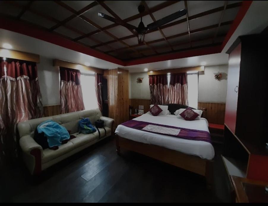 西隆Hotel Knight Inn Shillong的一间卧室配有一张床和一张沙发