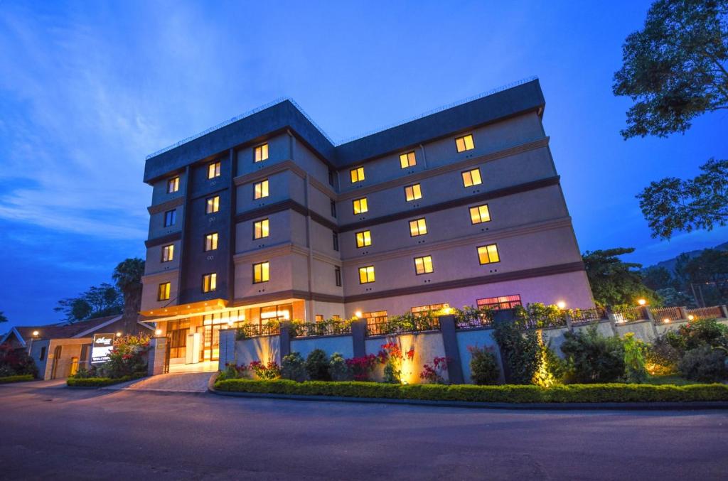 坎帕拉Best Western Plus The Athena Hotel Kampala的夜间灯光照亮的酒店大楼