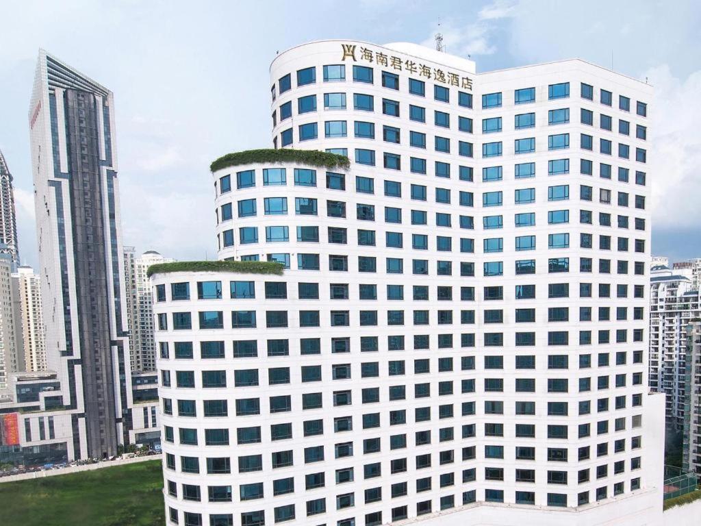 海口Hainan Junhua Haiyi Hotel的一座高大的白色建筑,窗户在城市里