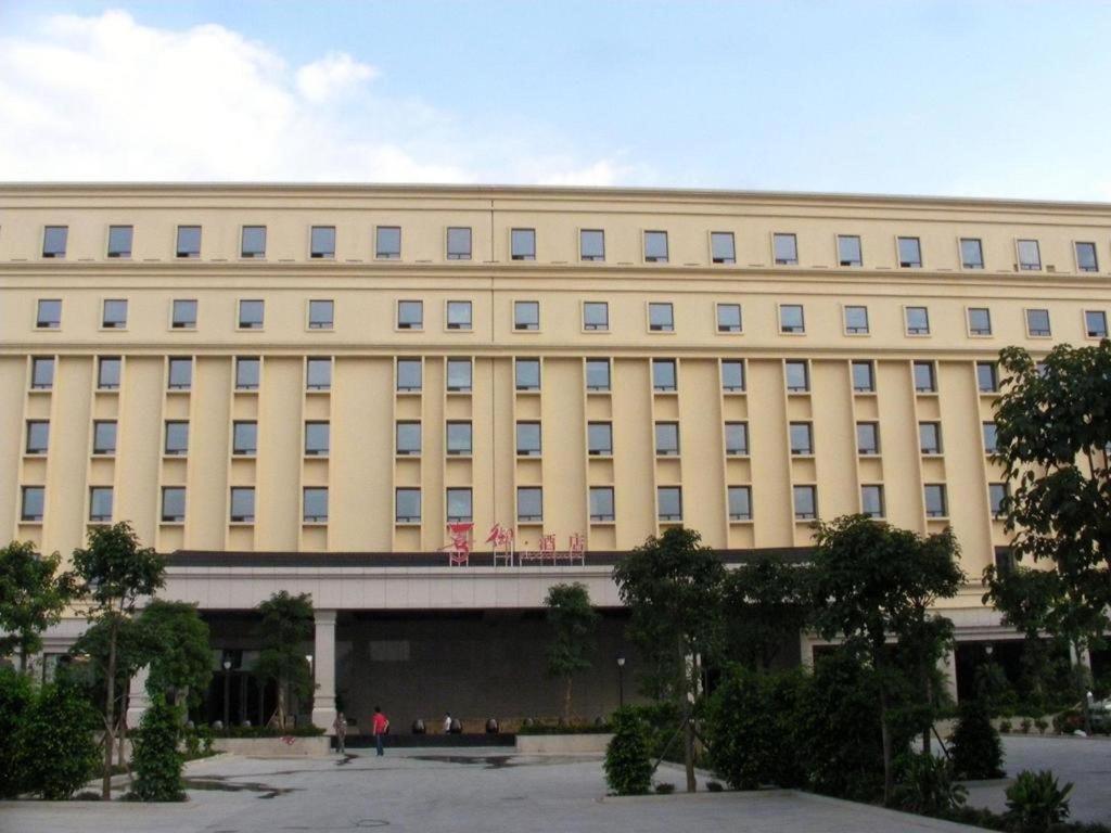 广州Xiyu Hotel的一座大型建筑,前面的人都站在