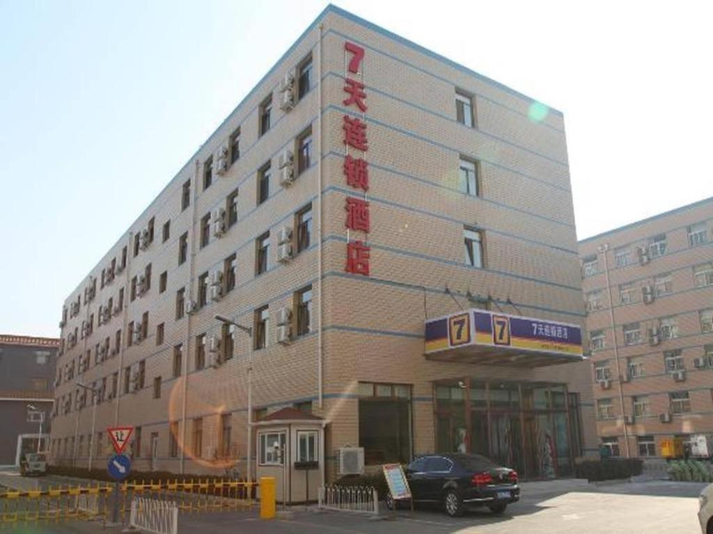 北京7 Days Inn Beijing Laiguangying Branch的前面有停车位的建筑