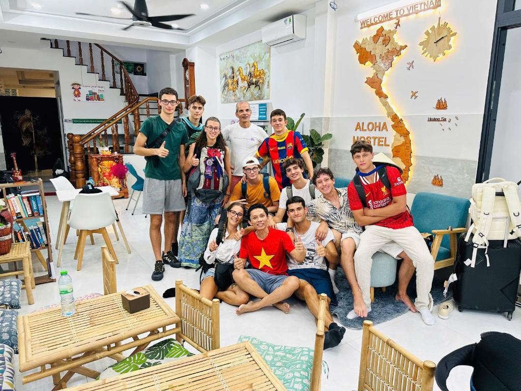 胡志明市ALOHA SAIGON HOSTEL by Local Travel Experts - Newly opened, Less-touristy location, Spacious rooms, Glass shower bathroom, Free breakfast, Quiet alley and Cultural exploration的一群人在客厅里拍照