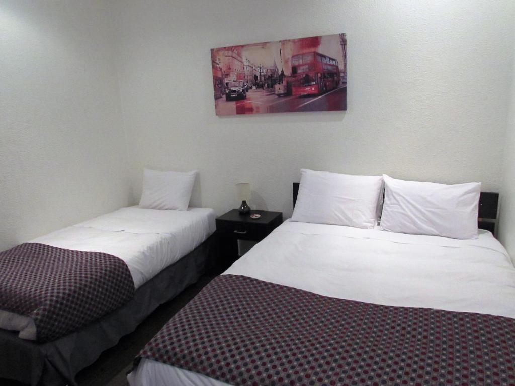 圣费尔南多Hotel Central San Fernando的两张睡床彼此相邻,位于一个房间里